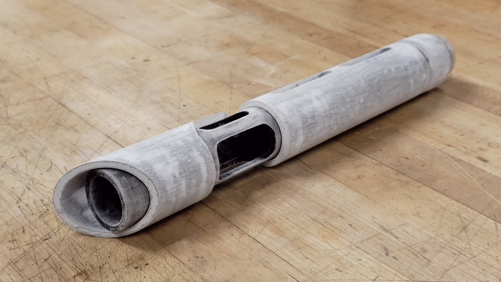 Lightsaber prop sanded almost to bare material sitting on a worktable.