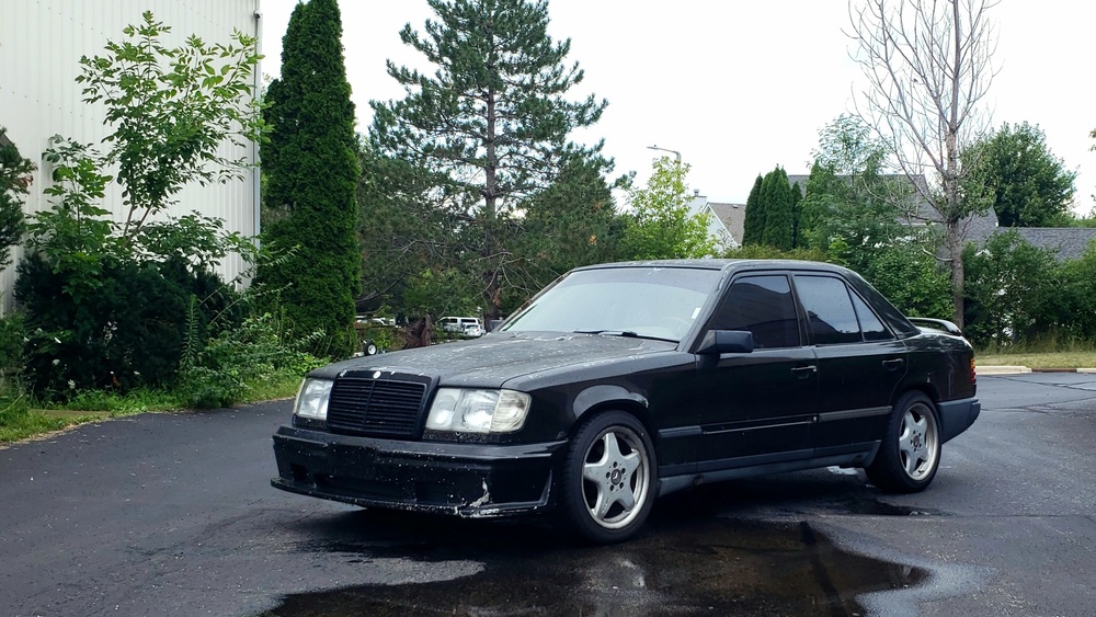 My 300E in three quarter view between two warehouse buildings.