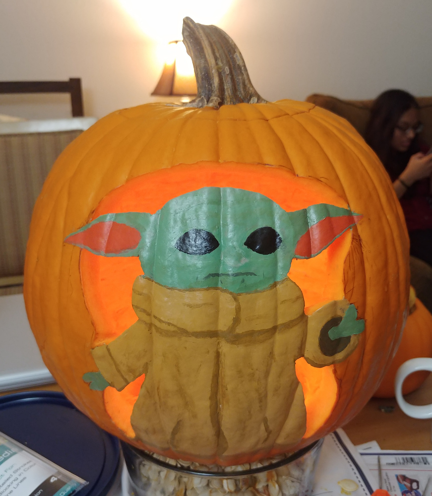 Picture of pumpkin with a painted carving of 'The Child' from the Mandalorian.