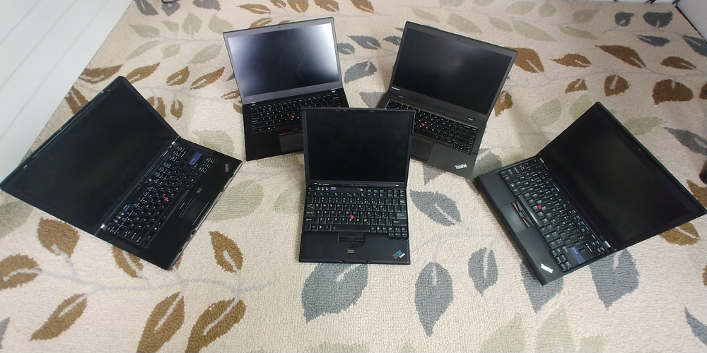 Group of five Lenovo ThinkPads facing in on each other.