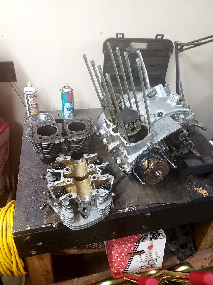 1981 XS650 engine laid out on work bench. The jugs, head, and lower half with pistons attached are separated.