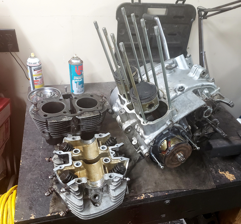 1981 XS650 engine laid out on work bench. The jugs, head, and lower half with pistons attached are separated.